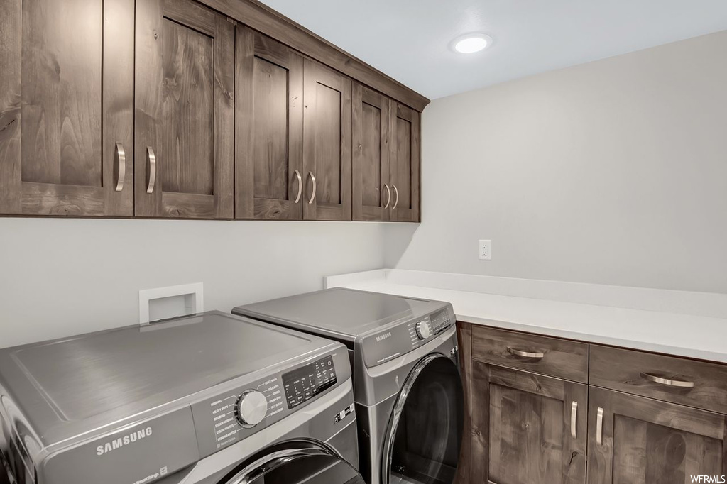 Laundry room featuring hookup for a washing machine, cabinets, and washing machine and dryer