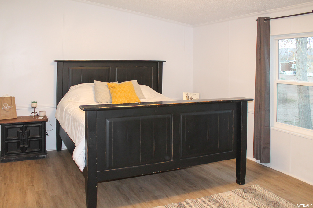 Bedroom featuring ornamental molding and hardwood / wood-style flooring