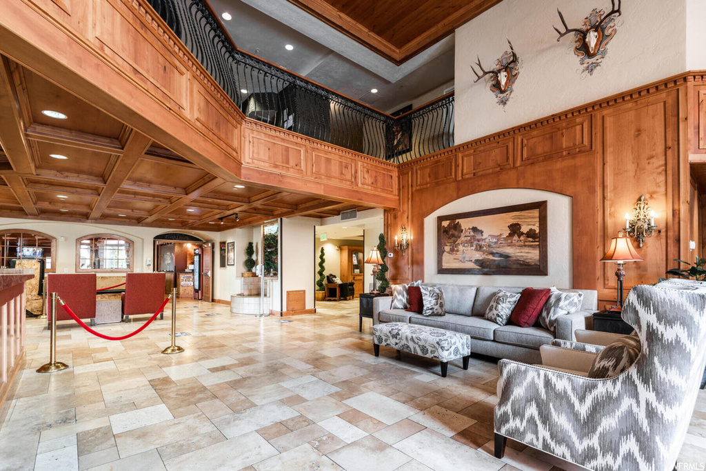 Tiled living room featuring wood ceiling, beam ceiling, coffered ceiling, and a towering ceiling