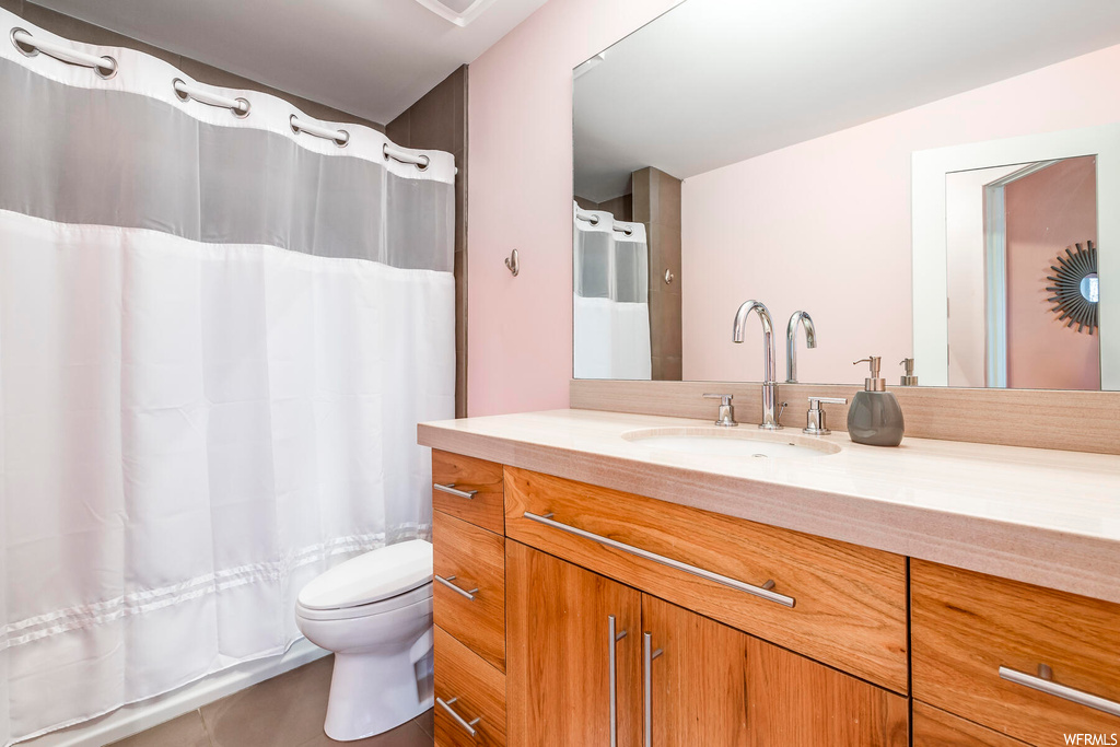 Bathroom with toilet, tile flooring, and large vanity
