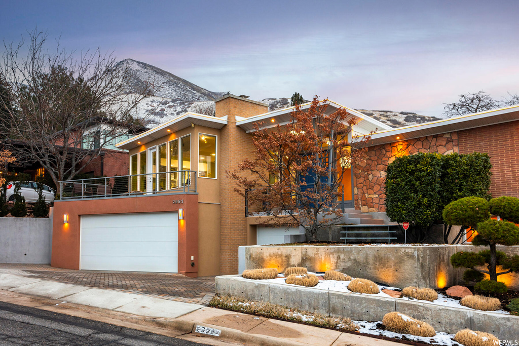 Contemporary home with a garage, a balcony, and a mountain view
