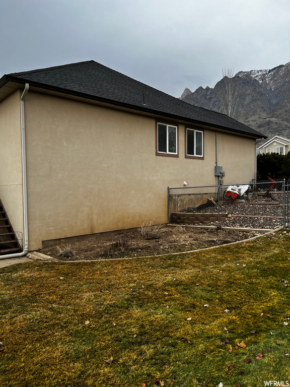 View of side of home featuring a yard and a mountain view