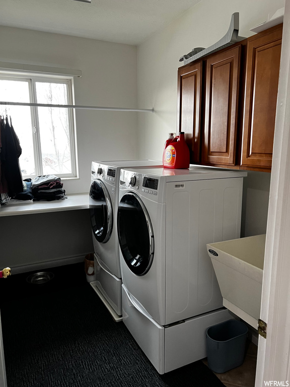 Laundry room featuring cabinets, separate washer and dryer, and sink