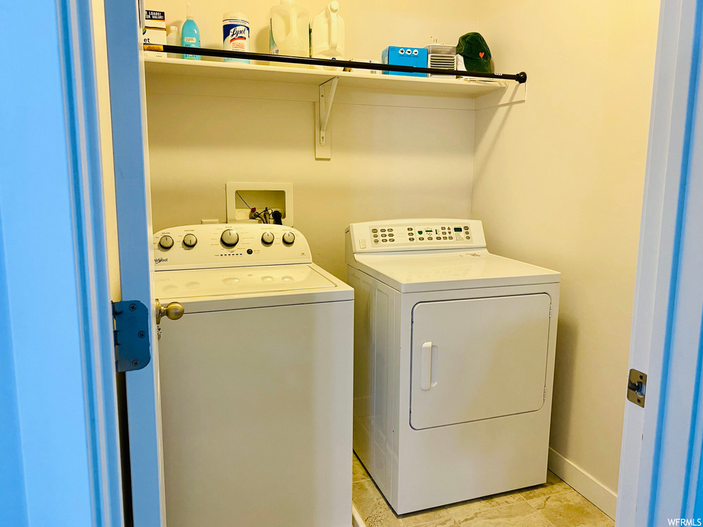 Laundry area featuring washer and clothes dryer, washer hookup, and light tile floors