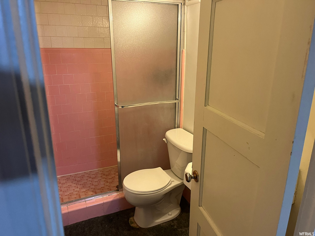 Bathroom with toilet and a shower with door