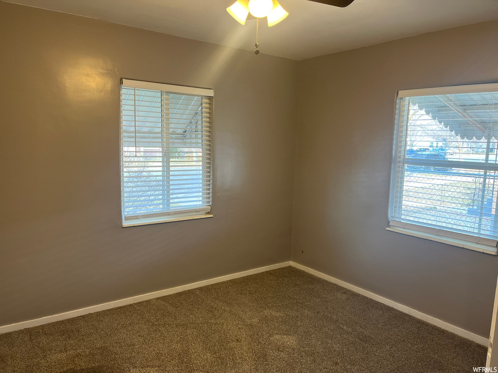Spare room featuring ceiling fan and carpet flooring