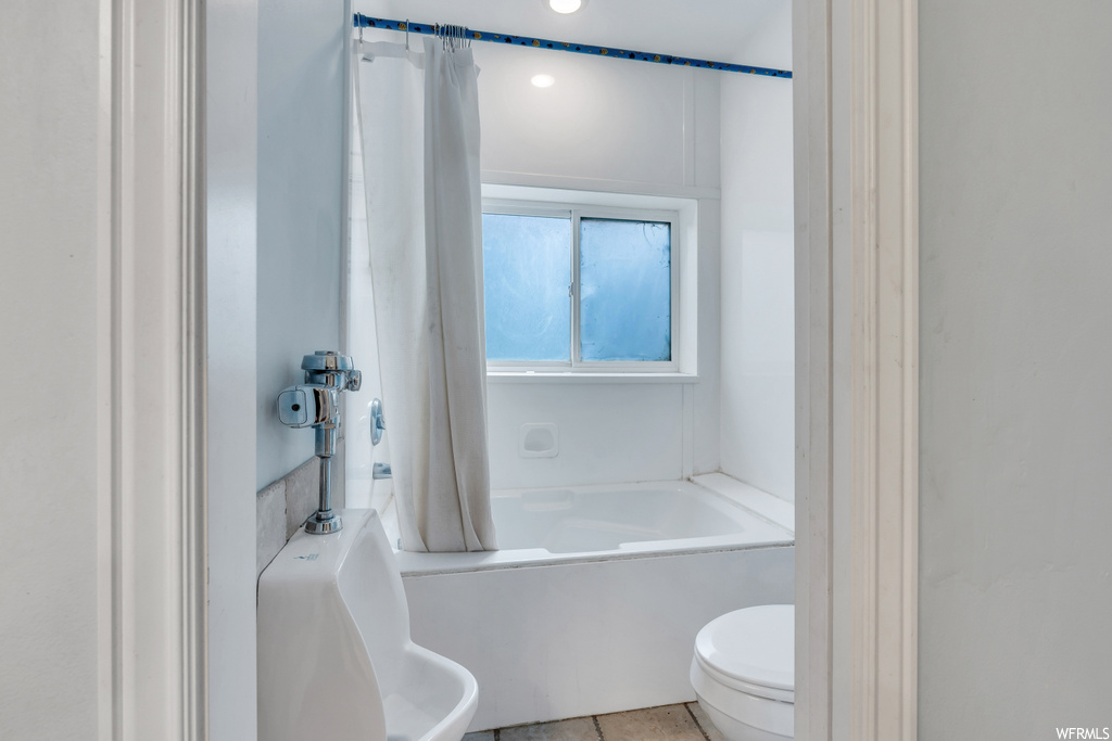 Full bathroom with sink, toilet, tile flooring, and shower / tub combo