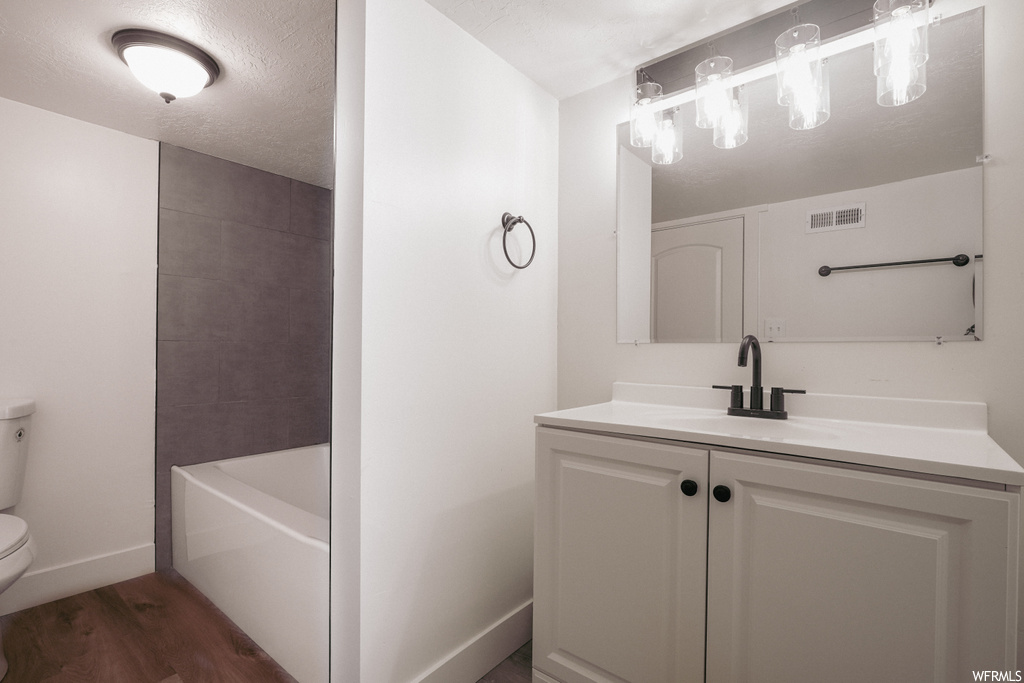 Full bathroom featuring shower / bath combination, vanity, toilet, and hardwood / wood-style floors
