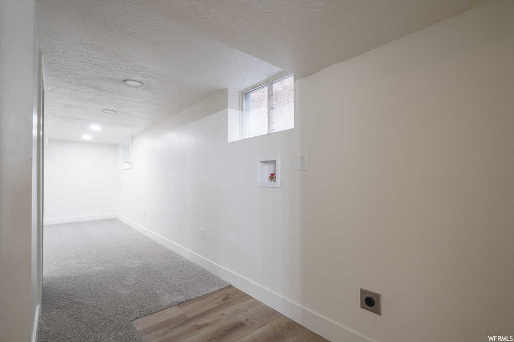 Hall featuring carpet flooring and a textured ceiling