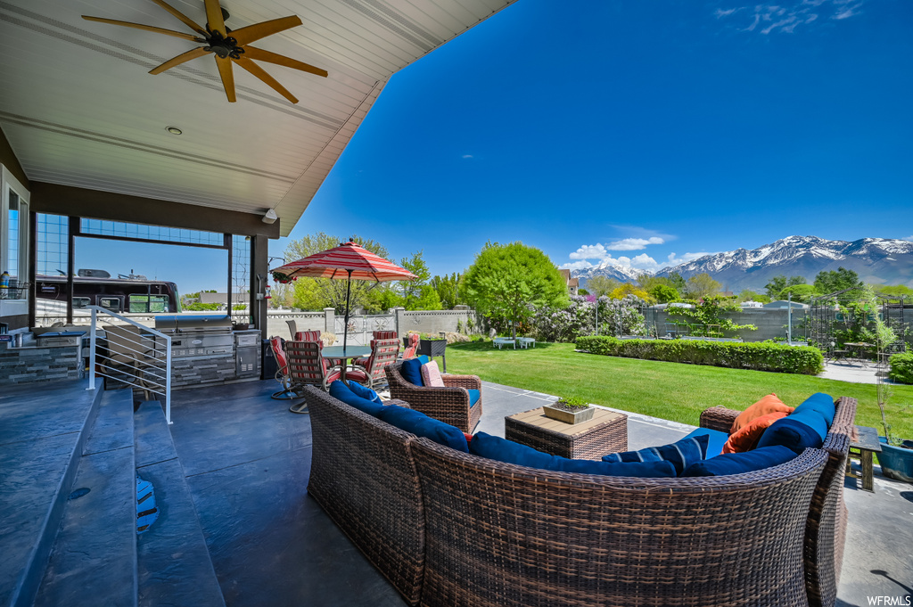 View of patio / terrace with an outdoor hangout area, ceiling fan, and a mountain view