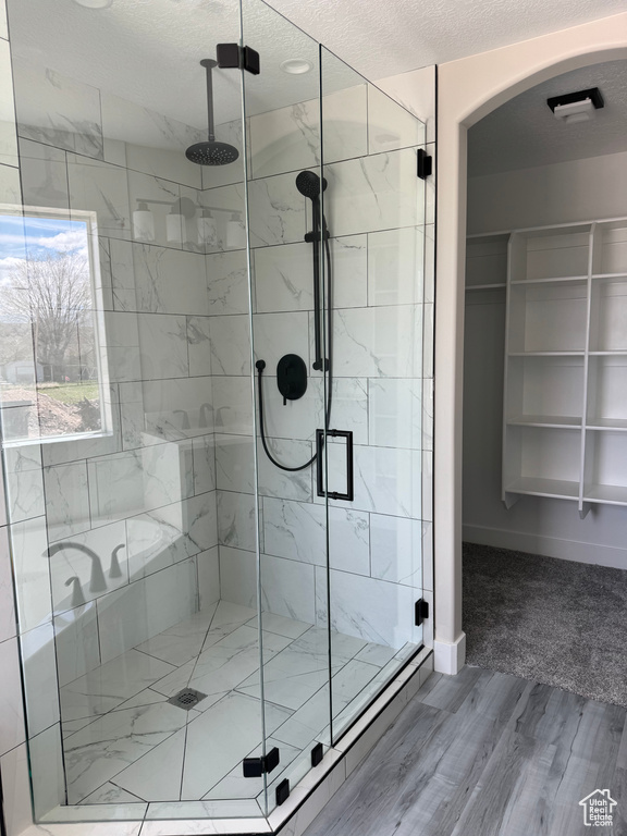 Bathroom featuring hardwood / wood-style flooring and plus walk in shower