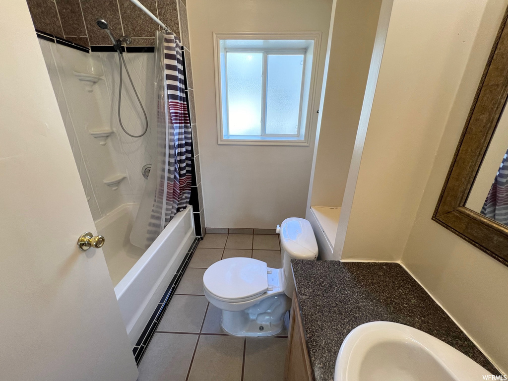Full bathroom with shower / bath combo with shower curtain, oversized vanity, tile floors, baseboard heating, and toilet