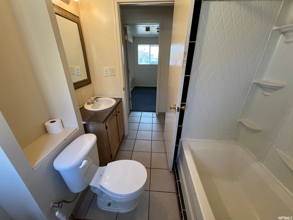 Full bathroom with tile floors, toilet, shower / washtub combination, and oversized vanity