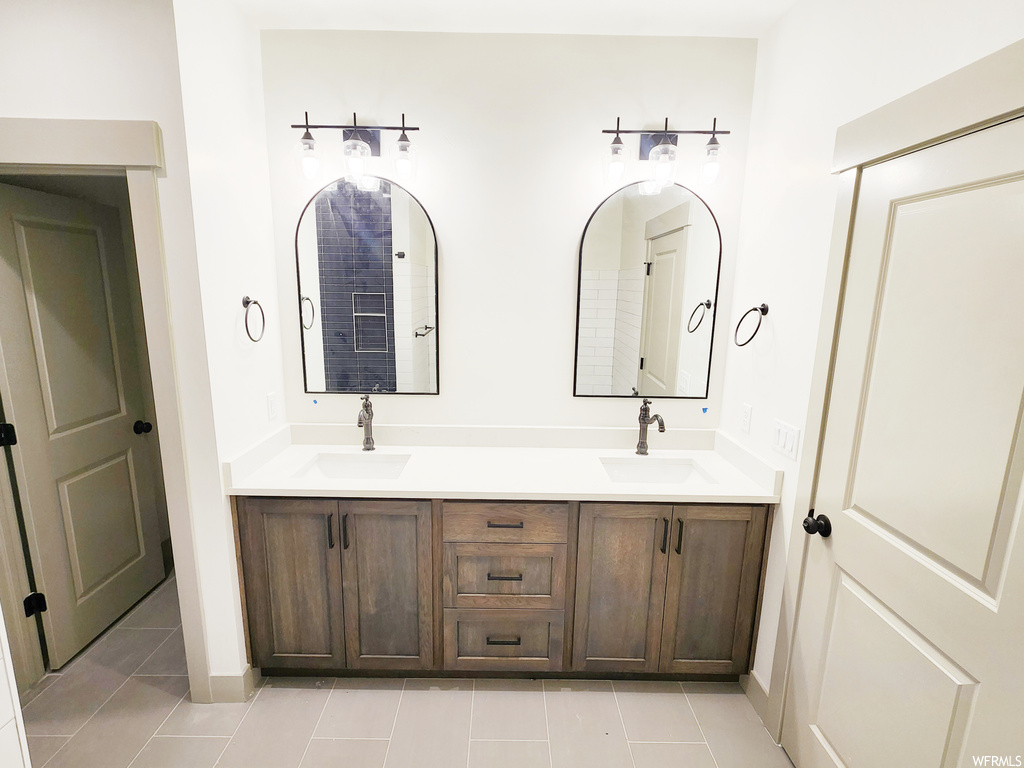 Bathroom featuring tile flooring and dual bowl vanity