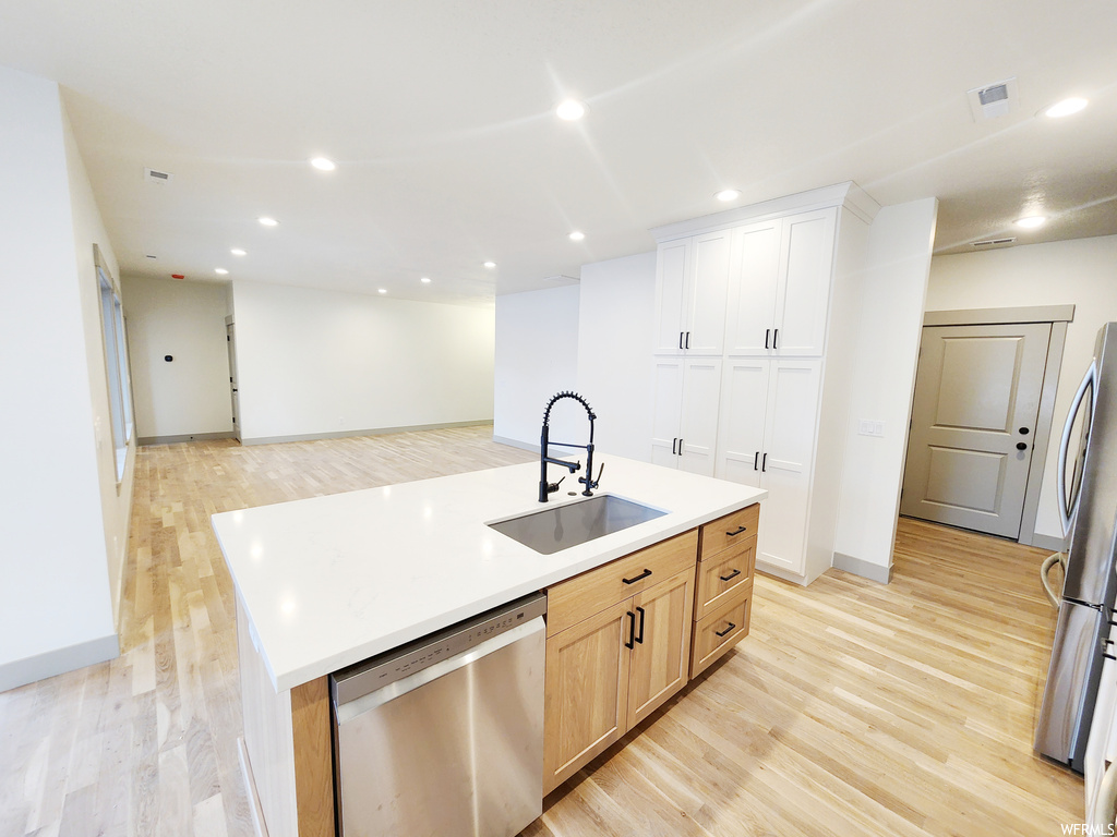 Kitchen featuring sink, light wood-type flooring, appliances with stainless steel finishes, and light brown cabinetry