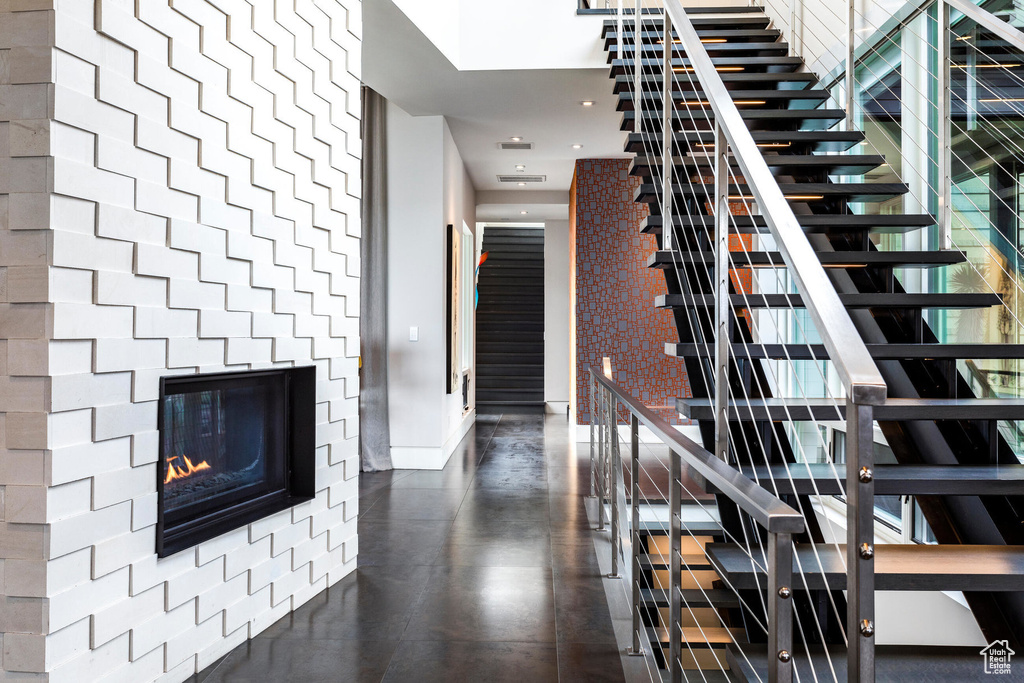 Staircase featuring a glass covered fireplace and recessed lighting