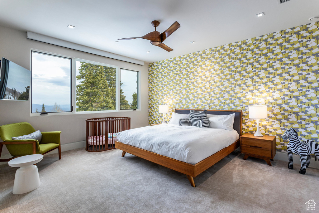 Carpeted bedroom with an accent wall, wallpapered walls, and baseboards