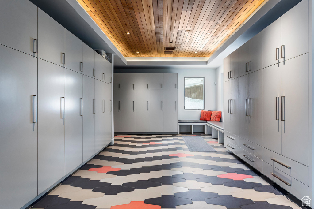 Mudroom featuring a raised ceiling, wooden ceiling, and light floors