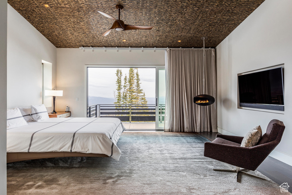 Bedroom with access to exterior, ceiling fan, and carpet flooring