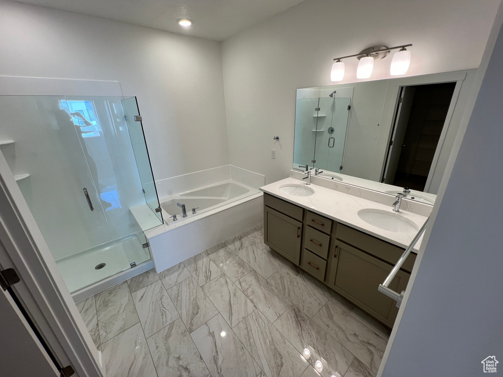 Bathroom featuring double sink vanity, tile floors, and plus walk in shower