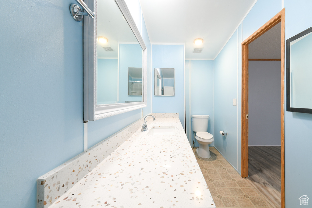 Bathroom featuring ornamental molding, toilet, tile floors, and vanity