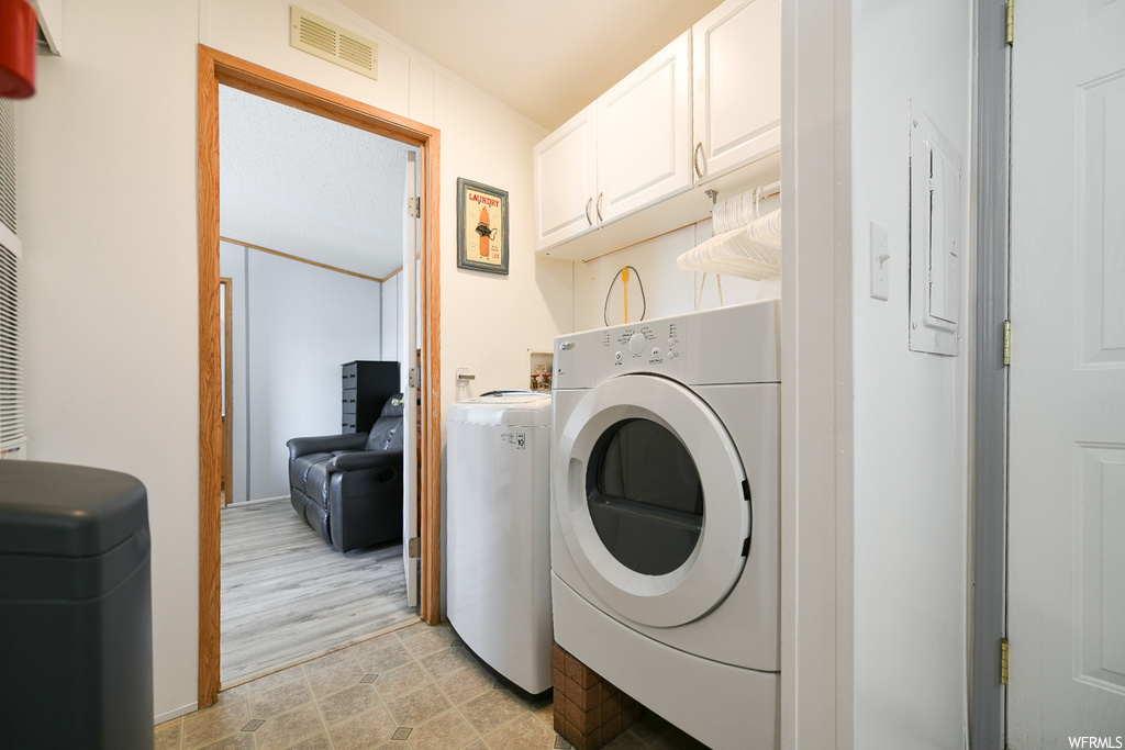 Laundry room with independent washer and dryer, cabinets, washer hookup, and light tile floors