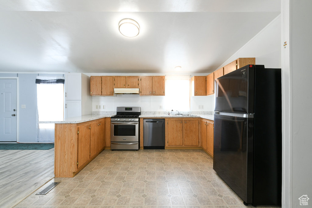Kitchen featuring plenty of natural light, appliances with stainless steel finishes, light hardwood / wood-style flooring, and kitchen peninsula