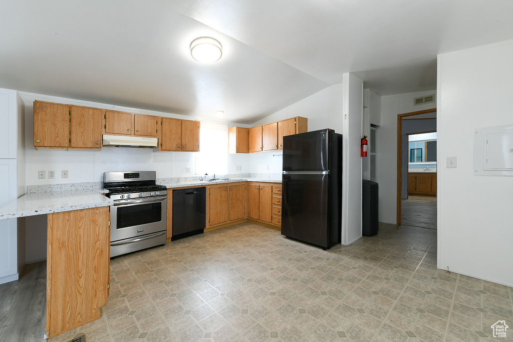 Kitchen with a kitchen breakfast bar, black appliances, and light tile flooring
