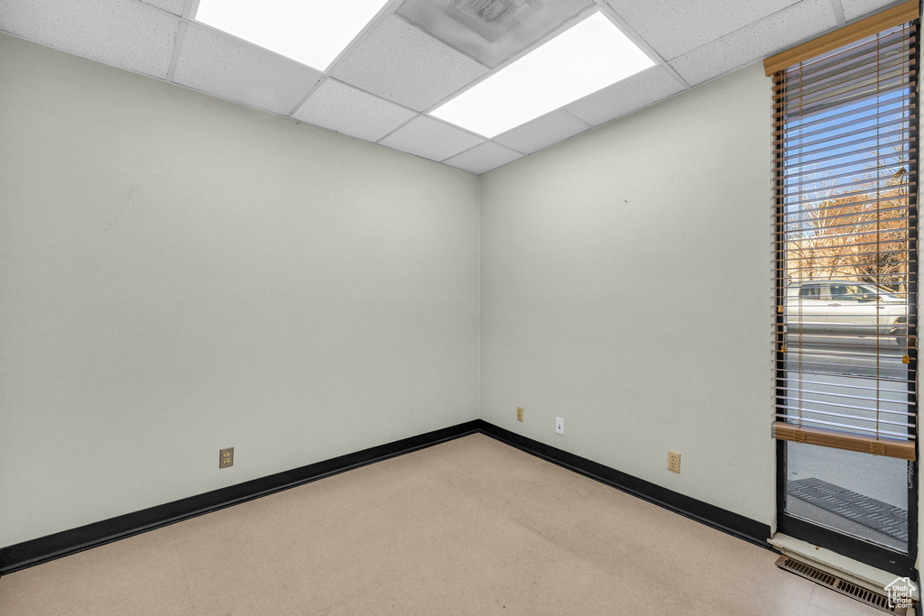 Unfurnished room with light colored carpet and a paneled ceiling
