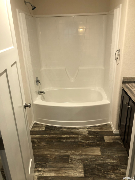 Bathroom featuring hardwood / wood-style floors, shower / washtub combination, and vanity