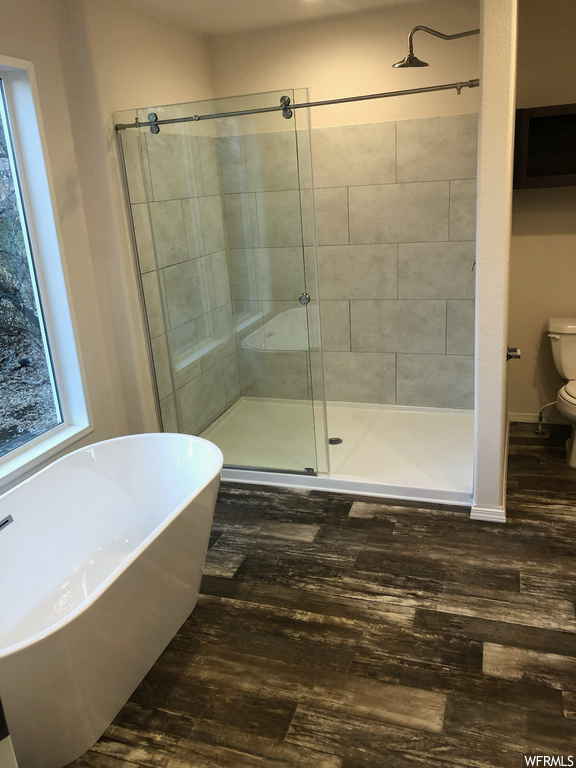 Bathroom with wood-type flooring, toilet, and separate shower and tub