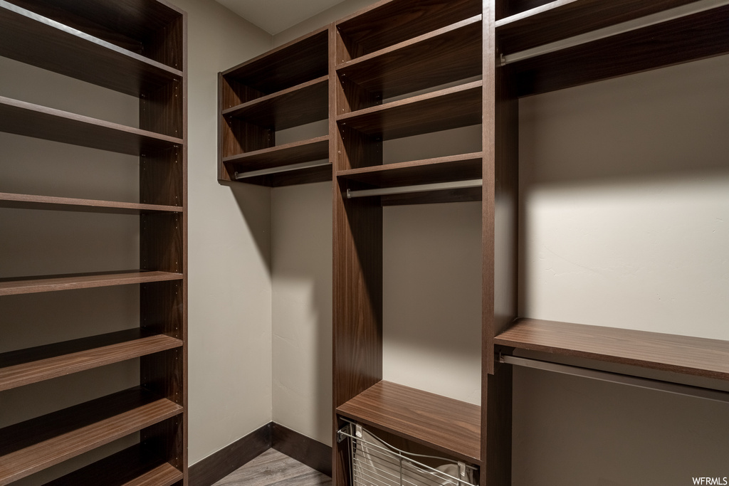 Spacious closet featuring hardwood / wood-style flooring