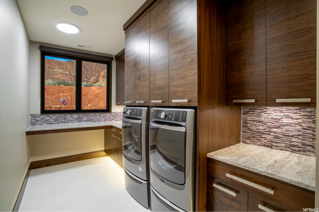 Washroom featuring light tile flooring and separate washer and dryer