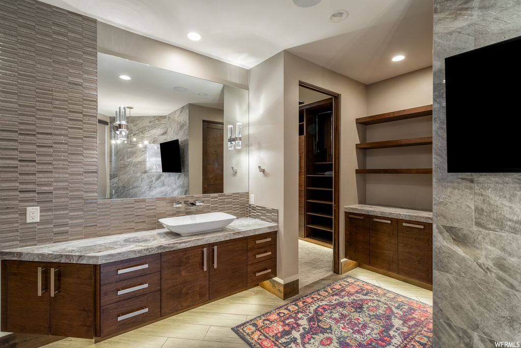 Bathroom with tile flooring, large vanity, and backsplash