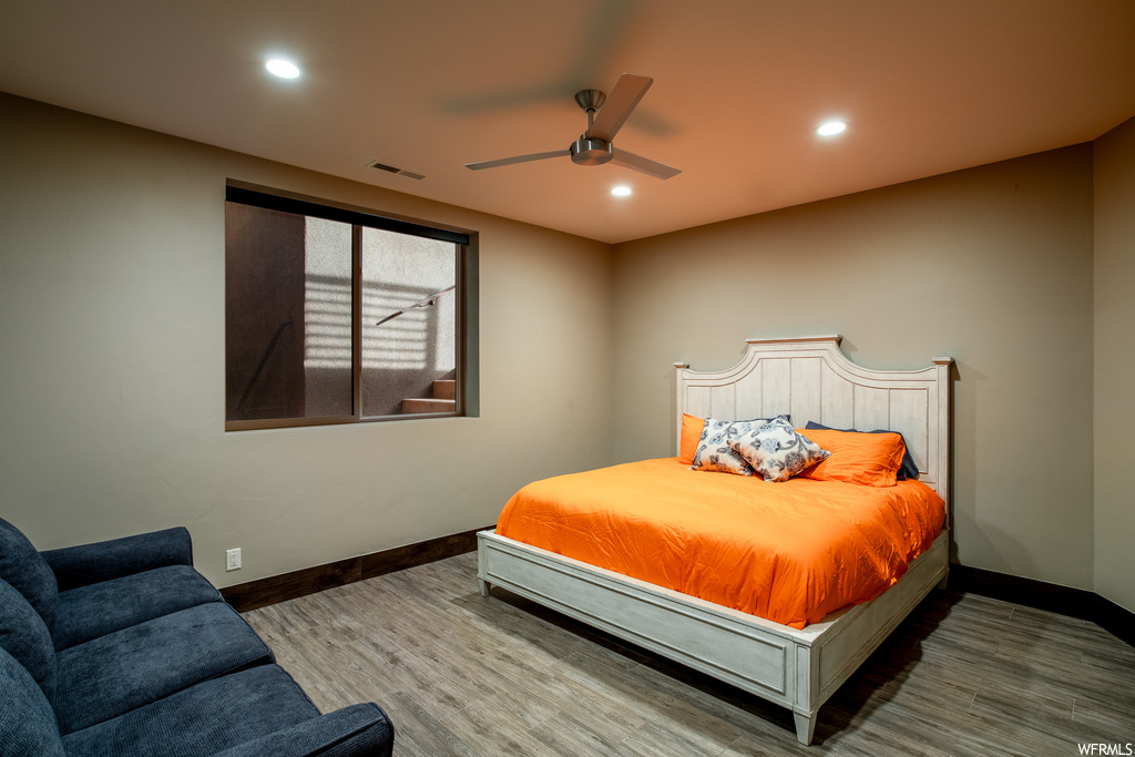 Bedroom with hardwood / wood-style flooring and ceiling fan
