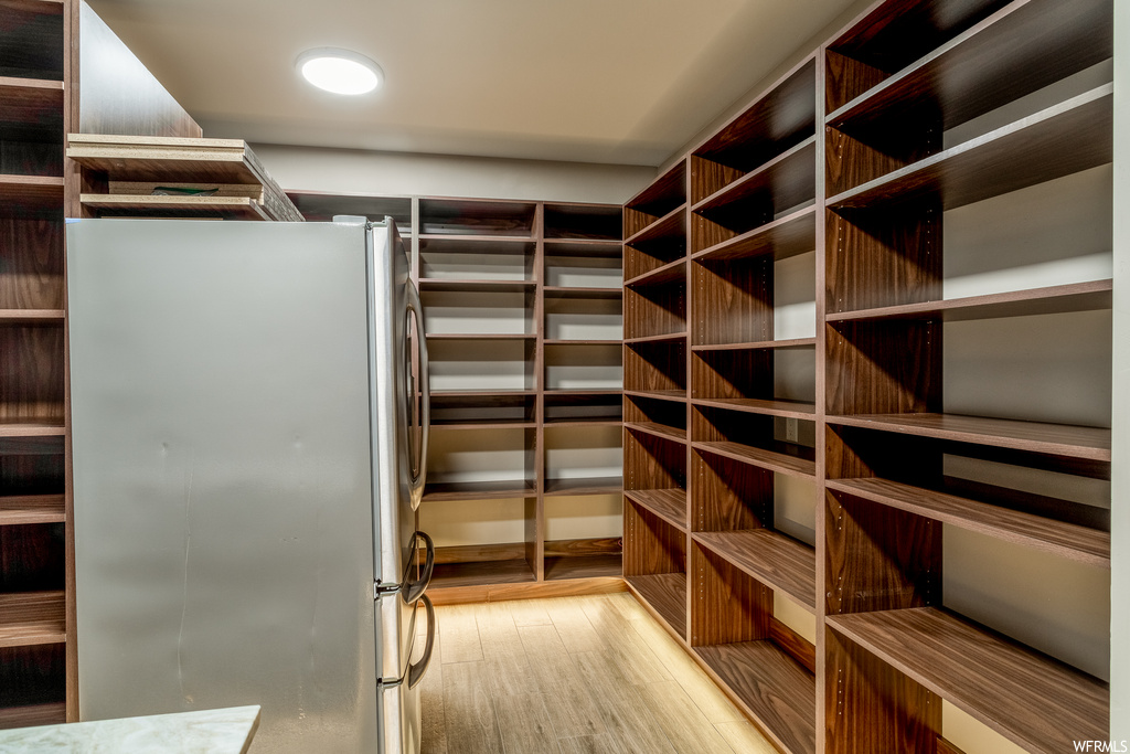 Spacious closet with light hardwood / wood-style floors