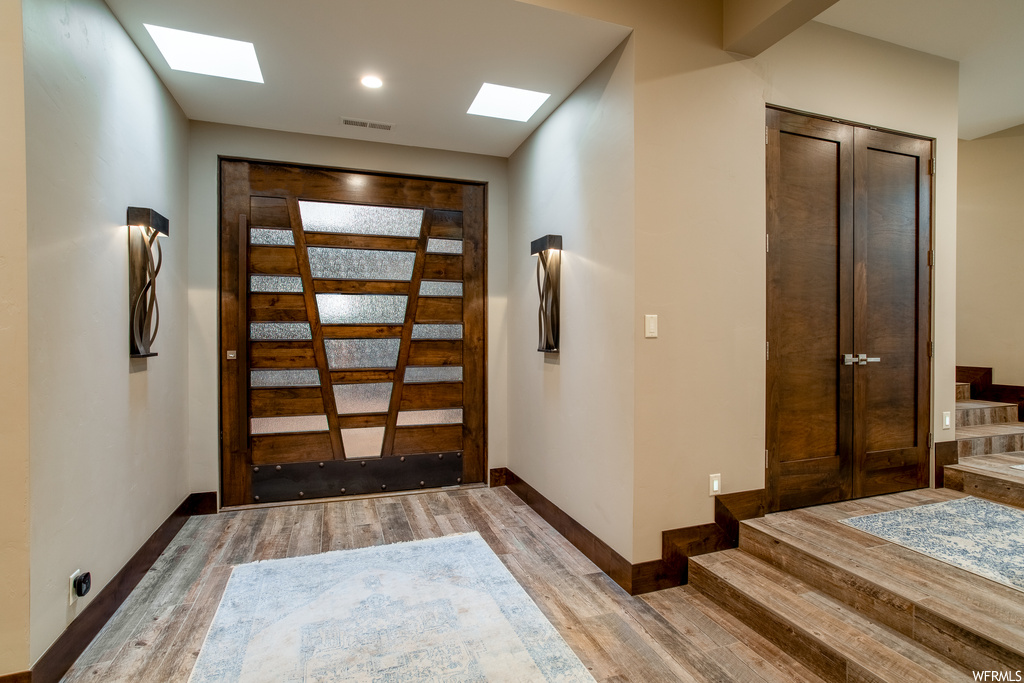 Foyer featuring dark hardwood / wood-style flooring and a skylight