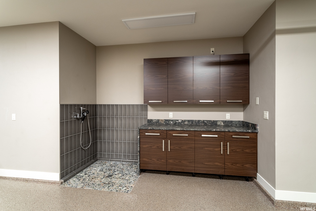 Interior space with dark brown cabinets and dark stone countertops