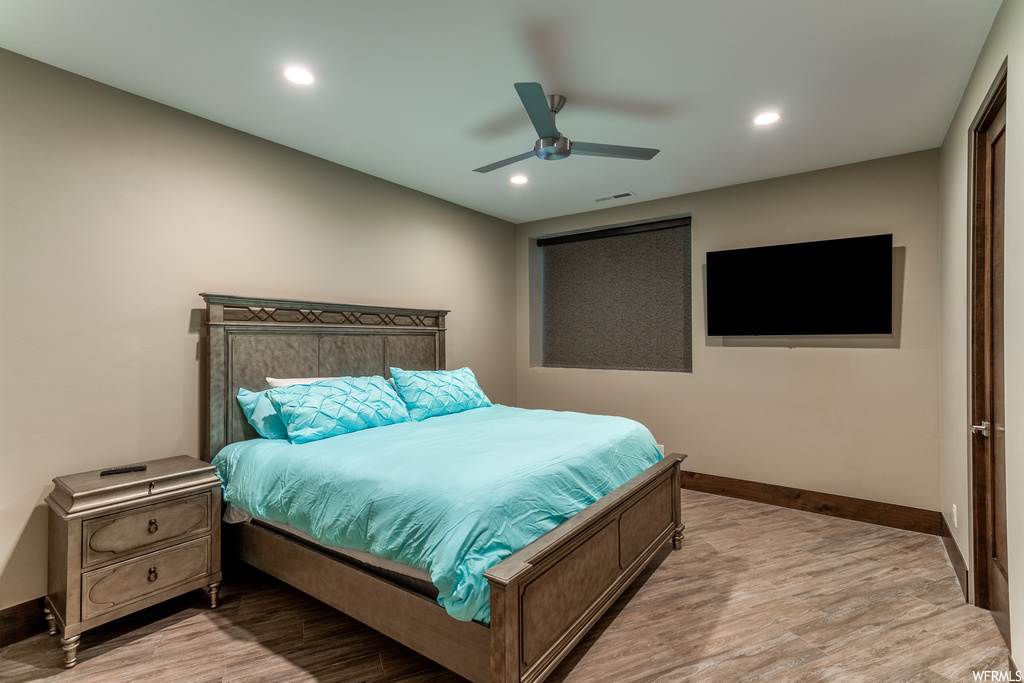 Bedroom with light hardwood / wood-style floors and ceiling fan