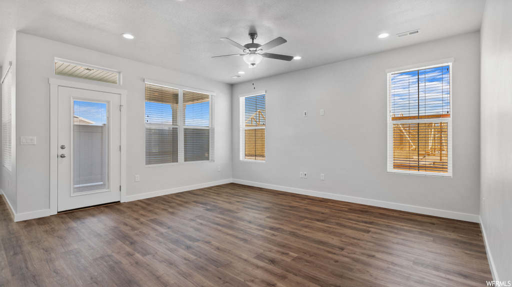 Spare room featuring dark hardwood / wood-style flooring and ceiling fan