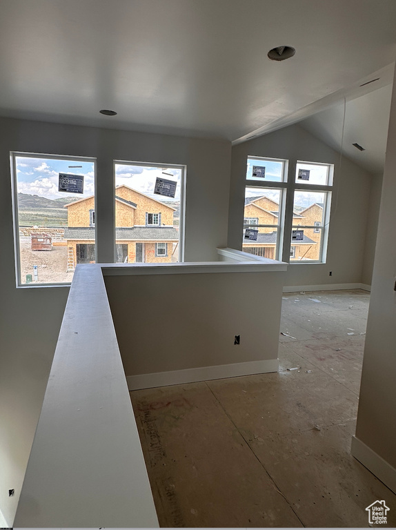 Corridor with lofted ceiling and a healthy amount of sunlight