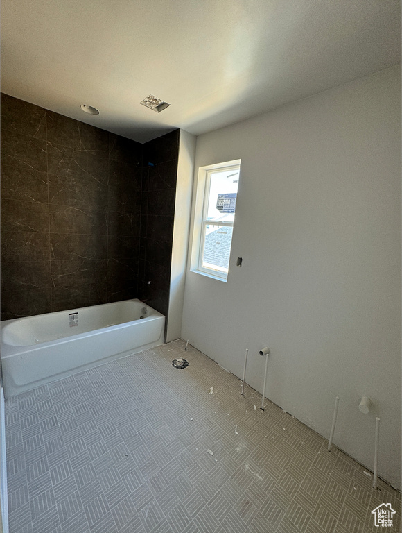 Bathroom featuring tiled shower / bath and tile patterned floors