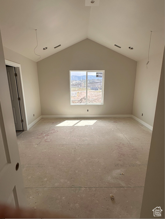 Unfurnished room featuring vaulted ceiling