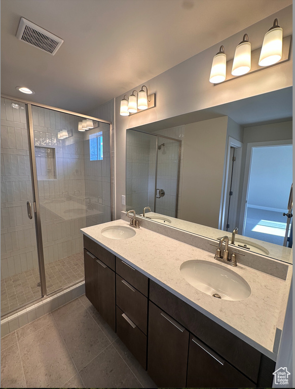 Bathroom with tile patterned flooring, walk in shower, and vanity