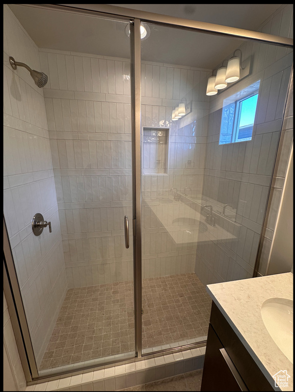 Bathroom with vanity and a shower with shower door