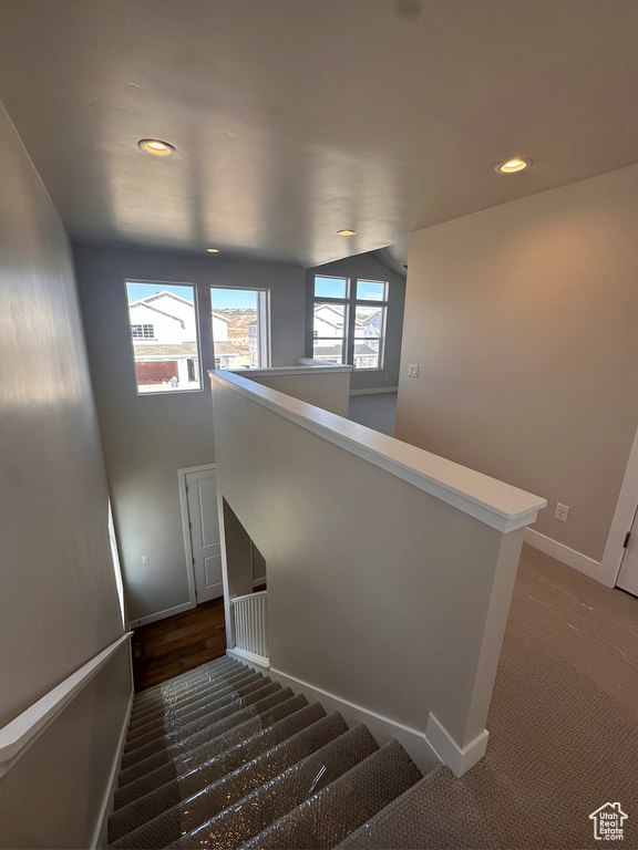 Staircase with lofted ceiling and carpet flooring