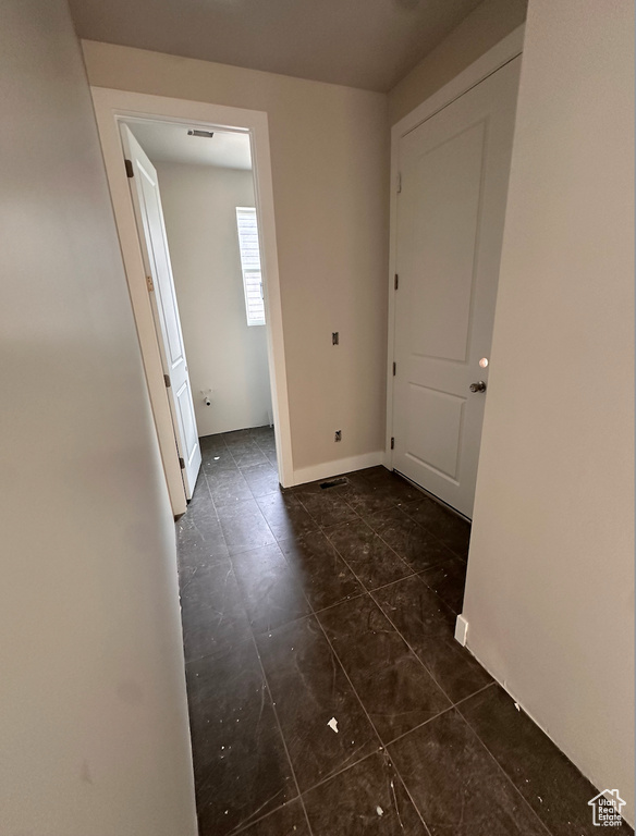 Corridor with dark tile patterned flooring