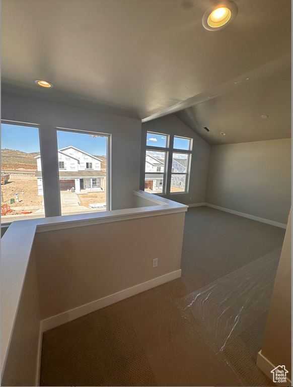 Interior space with carpet floors and lofted ceiling