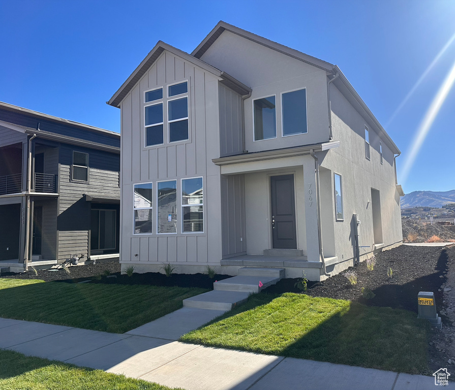 View of front of property featuring a mountain view and a front yard