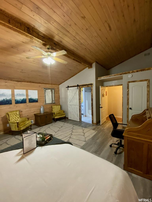 Bedroom with light hardwood / wood-style floors, ceiling fan, wood ceiling, vaulted ceiling with beams, and a barn door